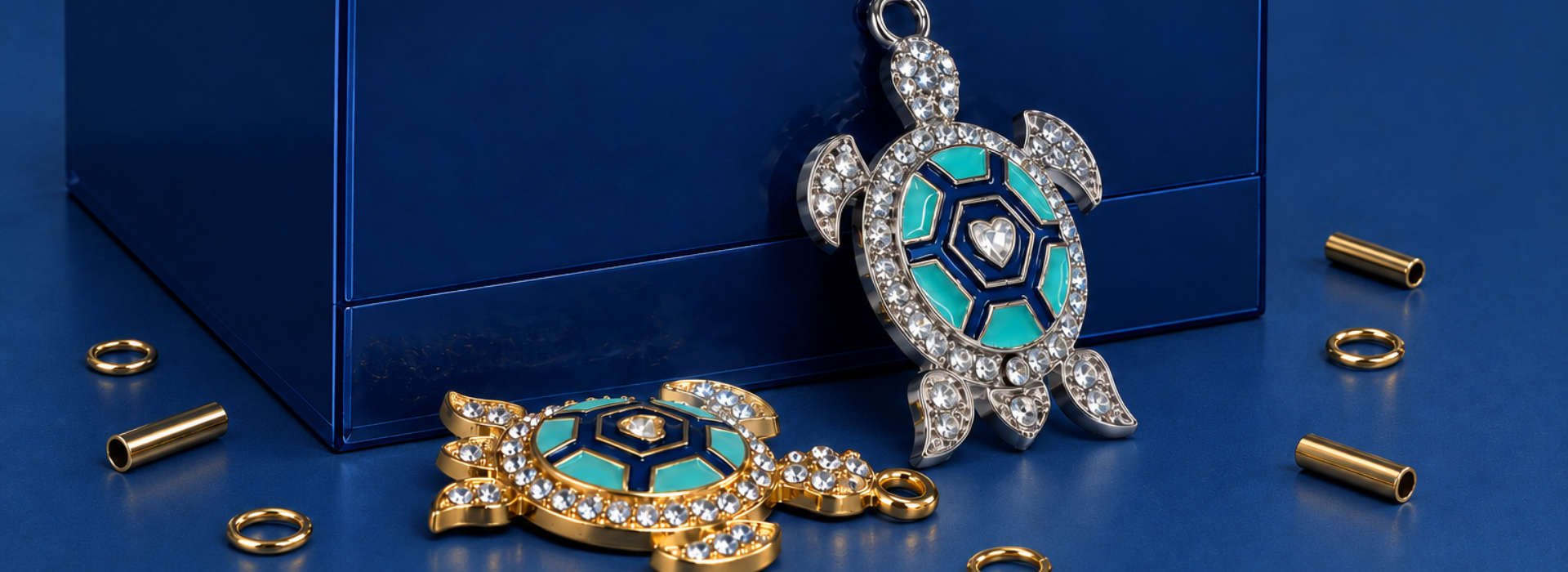 Pingentes de tartaruga com cristais e detalhes turquesa sobre fundo azul da Nil Arte